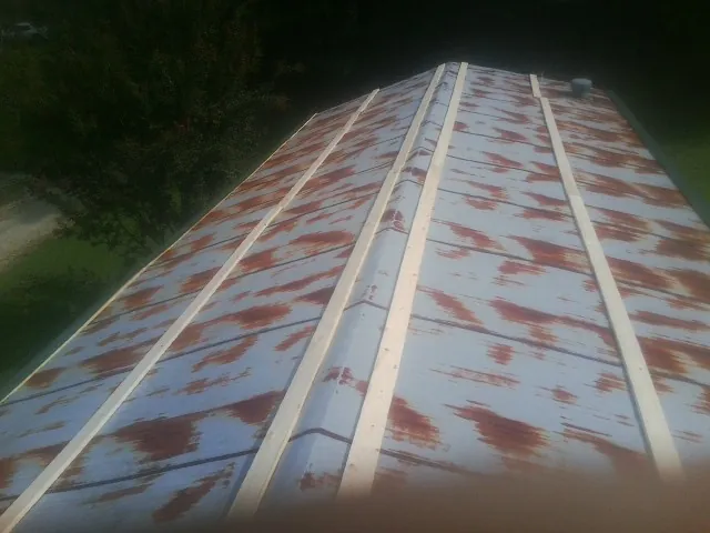 Rusted metal roof panels with new wood purlins before replacement — Storm Damage Roof Repair in Kila by Roofing Brothers