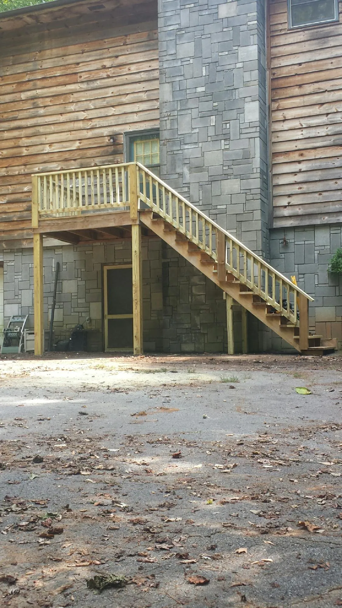 New pressure treated deck and stair landing on a log home in Kila